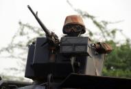 A French soldier holds a machine gun and stands guard atop an armored vehicule as a convoy of French army soldiers arrives in Sevare, in the Mopti region of Mali, on February 1, 2013. President Francois Hollande prepared to visit Mali as French-led troops worked Friday to secure the last Islamist stronghold in the north after a lightning offensive against the extremists