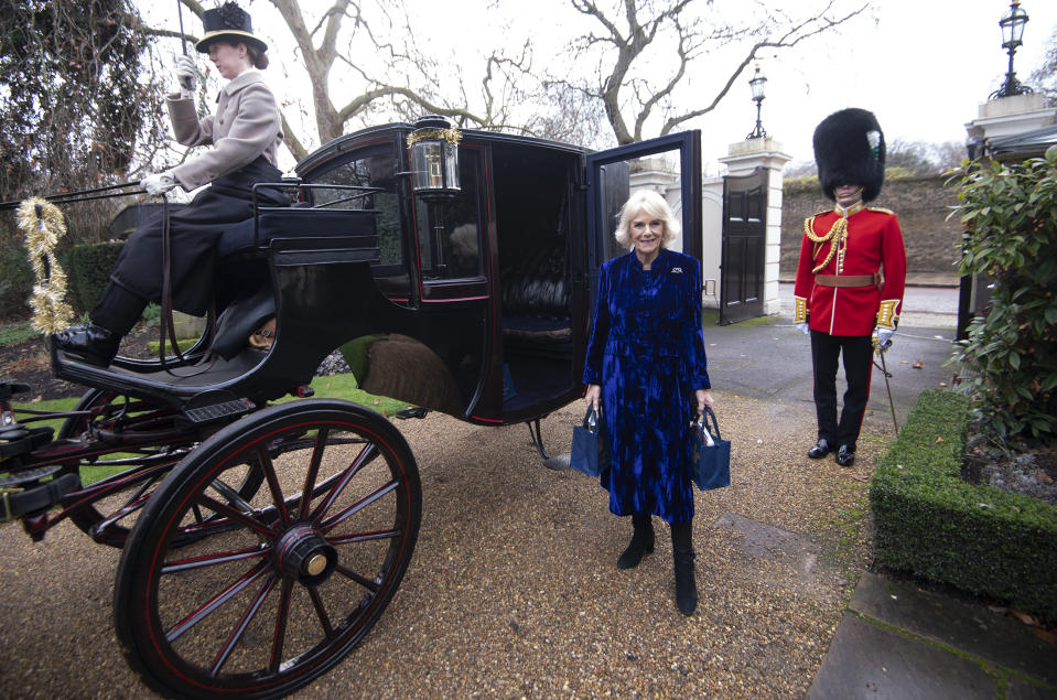 LONDON, ENGLAND - DECEMBER 16: Camilla, Duchess of Cornwall  bearing gifts at The Royal Brougham with Captain Charles Ross Assistant Equerry as the Duchess of Cornwall decorates the Clarence House Christmas Tree virtually with children from Helen & Douglas House Hospice, on December 16, 2020 in London, England. (Photo by Eddie Mulholland - WPA Pool/Getty Images)