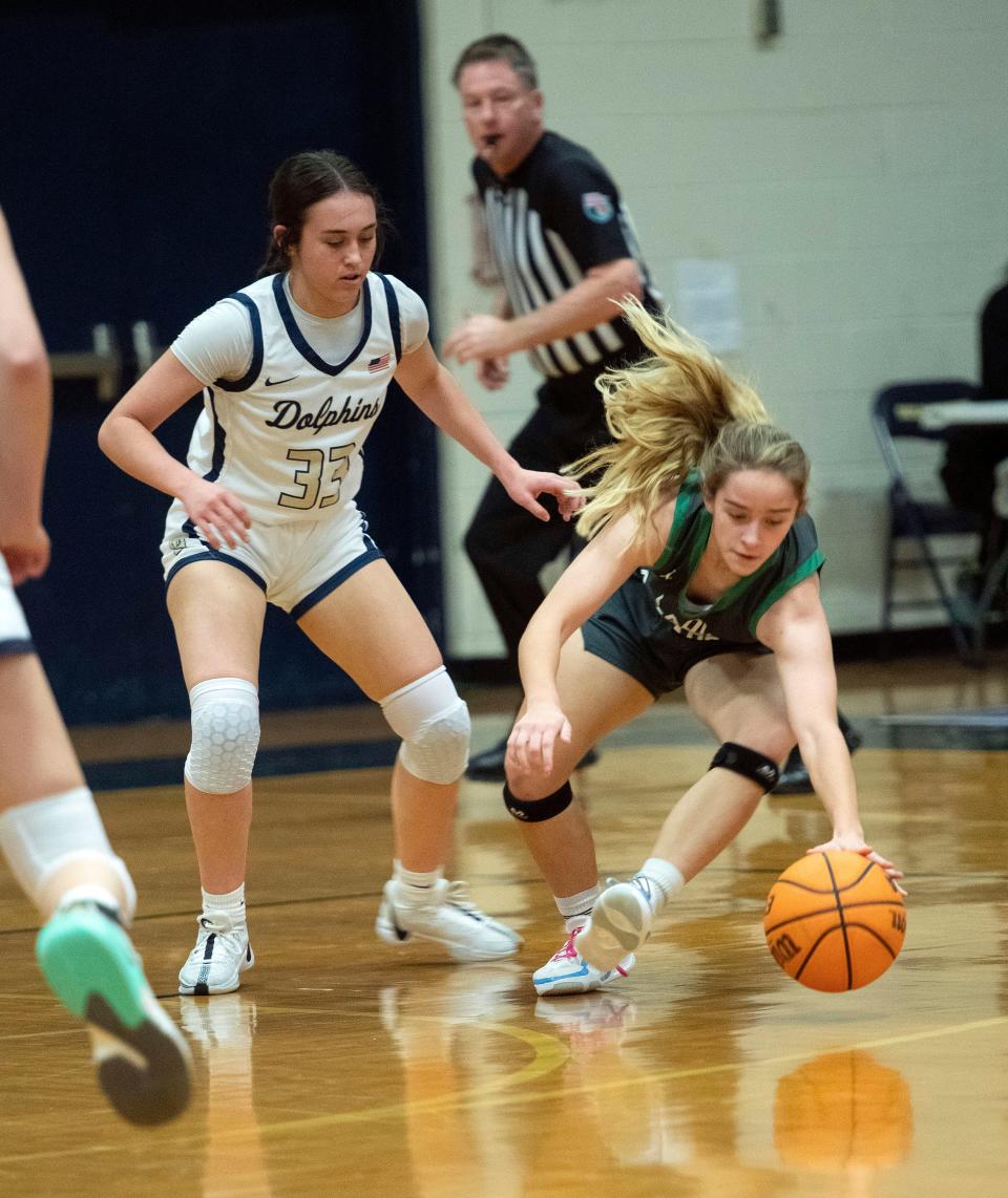 Northview Academy's Jordan White (No. 10) picks up a loose Gulf Breeze ball while defender Madison Coughlin (No. 33) looks on during the Innisfree Hotels Beach Basketball Tournament on Friday, Dec. 29, 2023.