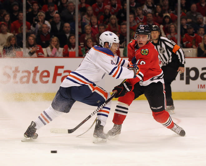 CHICAGO, IL - JANUARY 02: Jonathan Toews #19 of the Chicago Blackhawks fires a shot past Taylor Hall #4 of the Edmonton Oilers at the United Center on January 2, 2012 in Chicago, Illinois. The Oilers defeated the Blackhawks 4-3. (Photo by Jonathan Daniel/Getty Images)