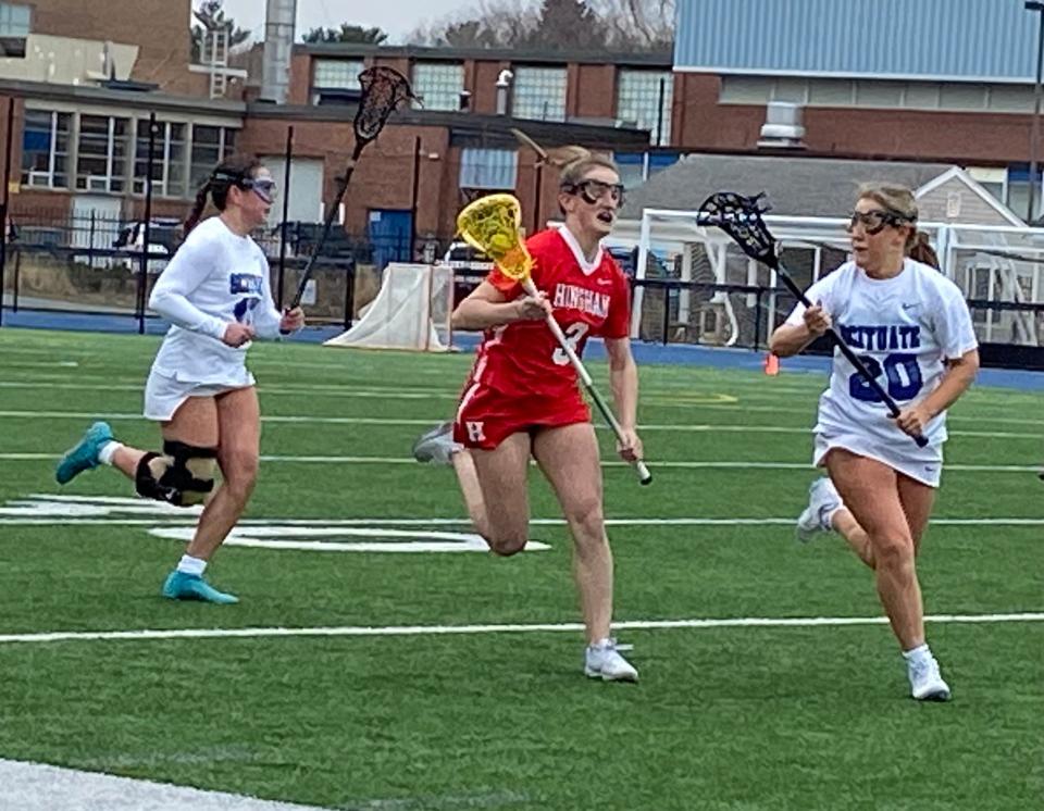 Hingham's Madeline Packard runs down the field with the ball.