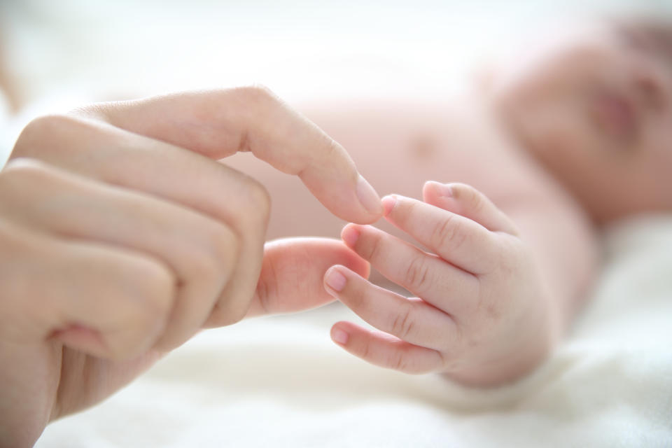 mother touching baby's hand