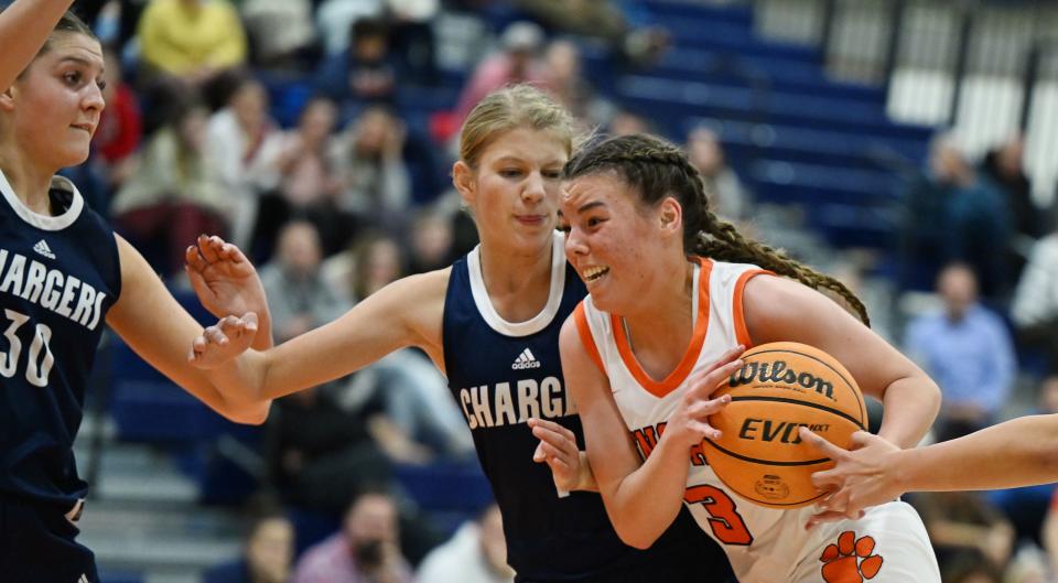 Brighton’s Taylor Workman drives on Corner Canyon’s Elina Mortensen and Kenzie Randall as they play at Brighton in Cottonwood Heights on Wednesday, Dec. 6, 2023. Brighton won 54-51. | Scott G Winterton, Deseret News