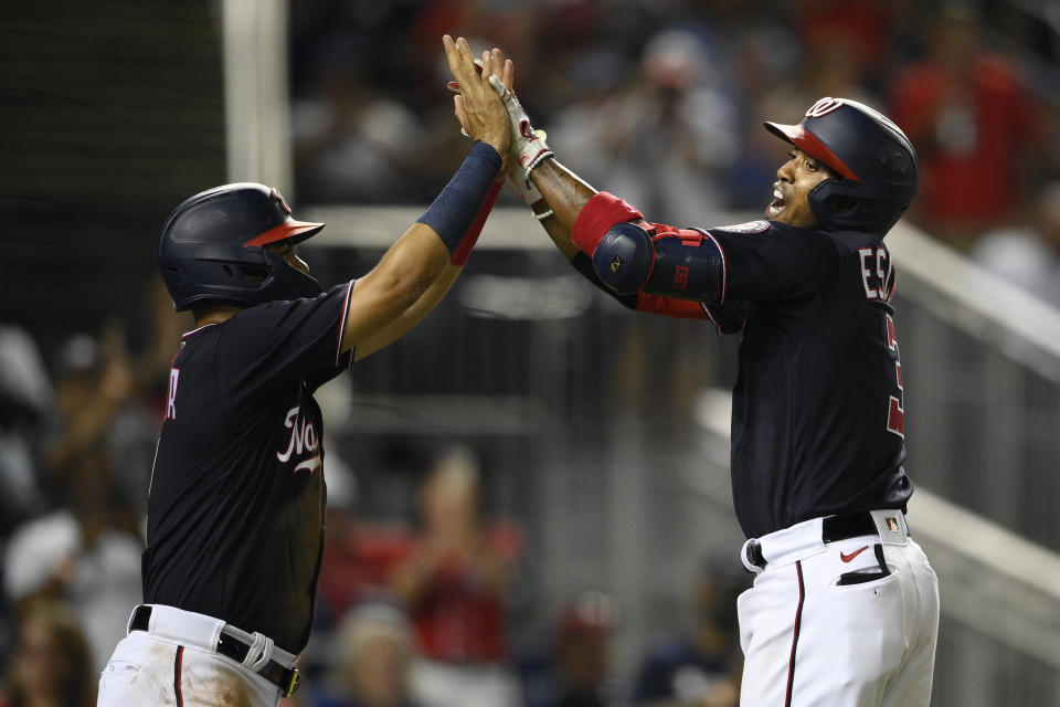 El venezolano Alcides Escobar (derecha), de los Nacionales de Washington, festeja con Luis García luego de conectar un jonrón de dos carreras en el encuentro del sábado 4 de septiembre de 2021, ante los Mets de Nueva York. Fue el segundo partido de una doble tanda (AP foto/Nick Wass)