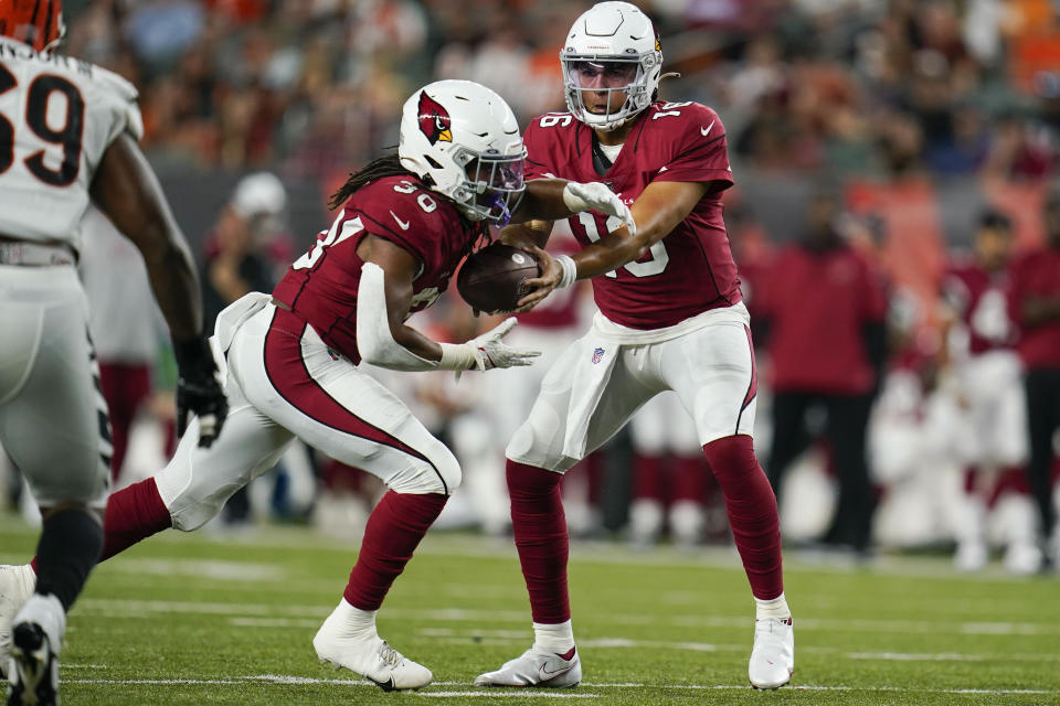 Arizona Cardinals running back Keaontay Ingram (30) receives a handoff from quarterback Jarrett Guarantano (16) during the second half of the team's NFL football preseason game against the Cincinnati Bengals in Cincinnati, Friday, Aug. 12, 2022. (AP Photo/Michael Conroy)