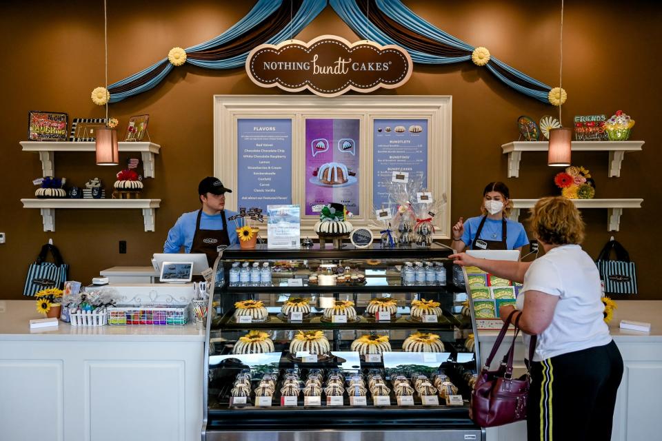 Nothing Bundt Cakes employees help a customer at the new Okemos location on Thursday, June 16, 2022.
