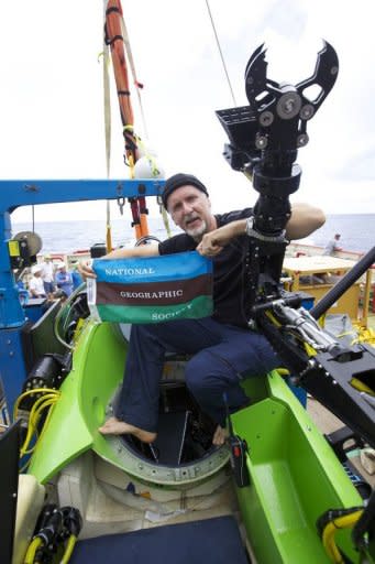 Filmmaker and National Geographic Explorer-in-Residence James Cameron holds the National Geographic Society flag after he successfully completed the first ever solo dive to the Mariana Trench, the deepest part of the ocean, on Monday. Speaking after the mission, the filmmaker-explorer described a barren "completely alien world" on the ocean floor, not unlike the surface of the moon