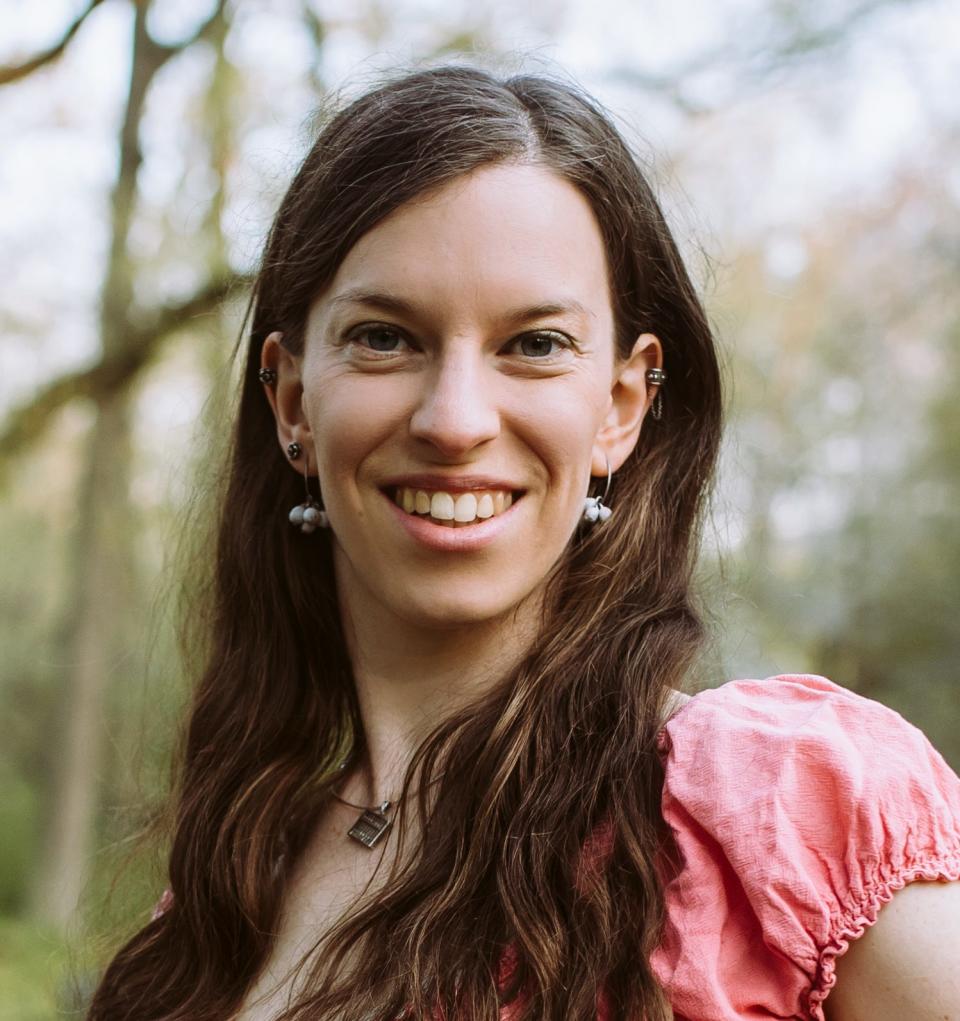 Headshot of Sarah Myerson, who had an ectopic pregnancy in 2018. She stands near trees wearing a pink short-sleeved top.