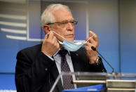 European Union foreign policy chief Josep Borrell takes off his protective face mask as he prepares to speak during a media conference after a meeting of EU foreign ministers at the European Council building in Brussels, Monday, Feb 22, 2021. (Johanna Geron, Pool via AP)