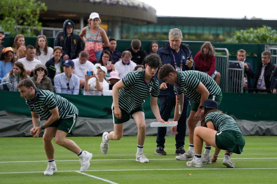 Ground staff remove pieces of confetti from Court 18 after being released by a Just Stop Oil protester (AP)