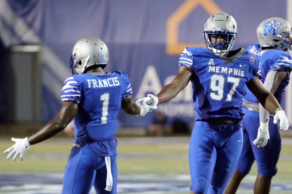 Oct 14, 2021; Memphis, Tennessee, USA; Memphis Tigers defensive linemen Wardalis Ducksworth (97) and defensive back Jacobi Francis (1) celebrate after a defensive stop during the first half against the Navy Midshipmen at Liberty Bowl Memorial Stadium. Mandatory Credit: Petre Thomas-USA TODAY Sports