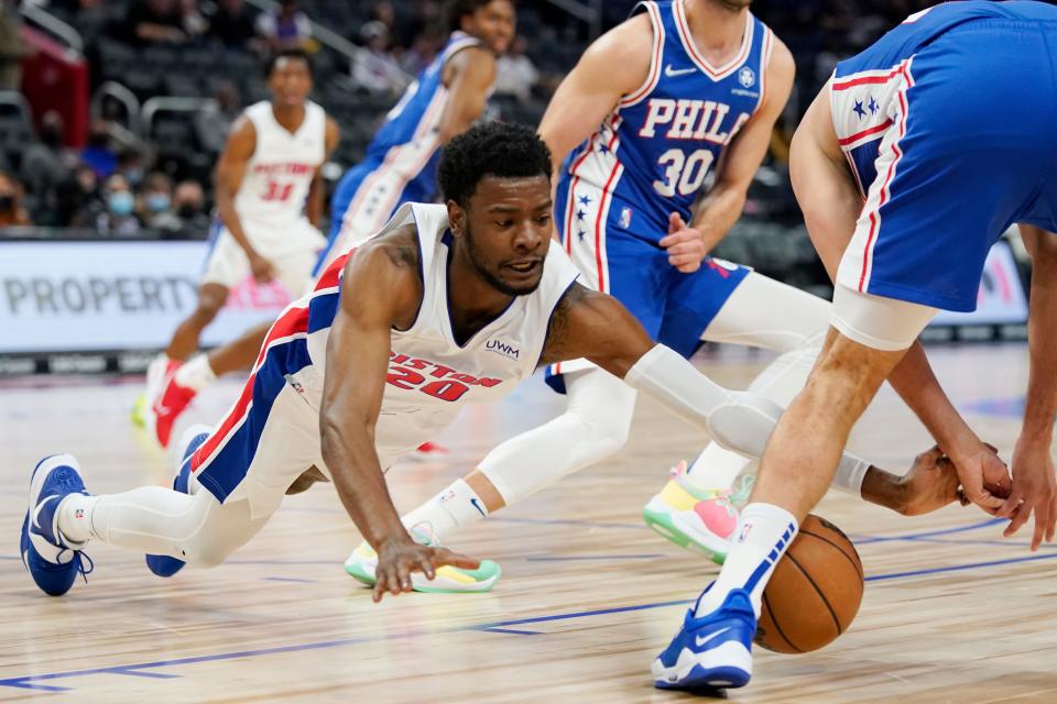 Detroit Pistons guard Josh Jackson reaches for the loose ball next to Philadelphia 76ers guard Furkan Korkmaz during the first half of an NBA basketball game, Friday, Oct. 15, 2021, in Detroit.