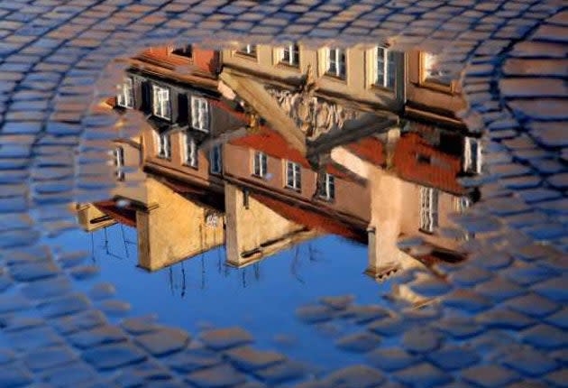 FILE-Warsaw’s Old Town, seen here reflected in a puddle (ANDRZEJ RYBCZYNSKI/EPA)