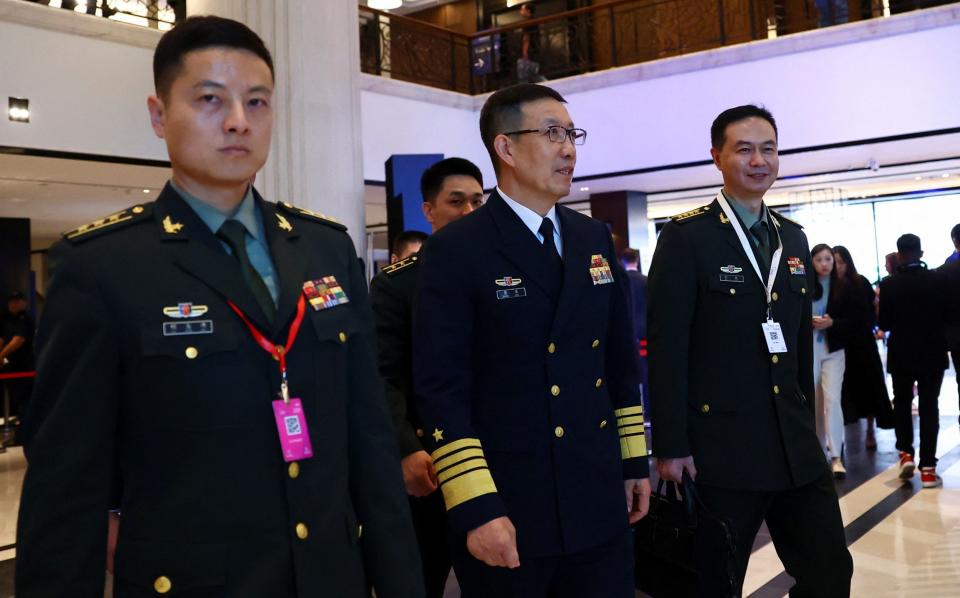 Chinese Defence Minister Dong Jun (c) walks to a meeting at the Shangri-La Dialogue in Singapore