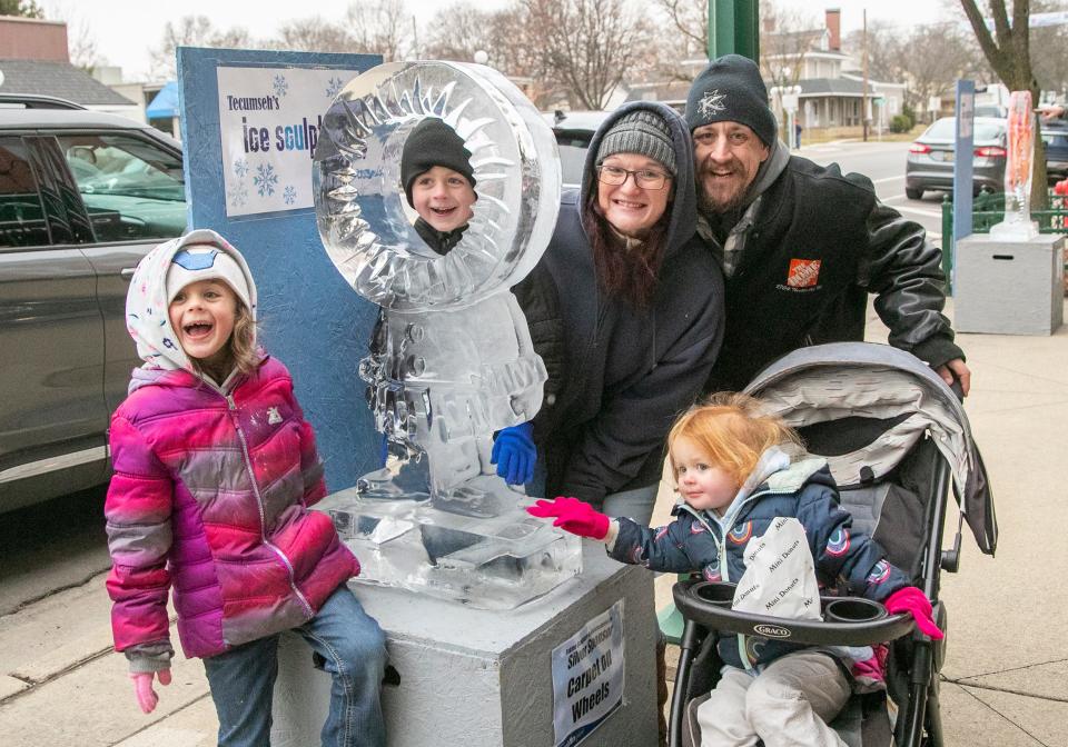 Brandy and Alex Pierpoint of Monroe pose with children Xavier, in sculpture, Arya, left, and Noora Jan. 21, 2023, during the Tecumseh Ice Sculpture Festival.