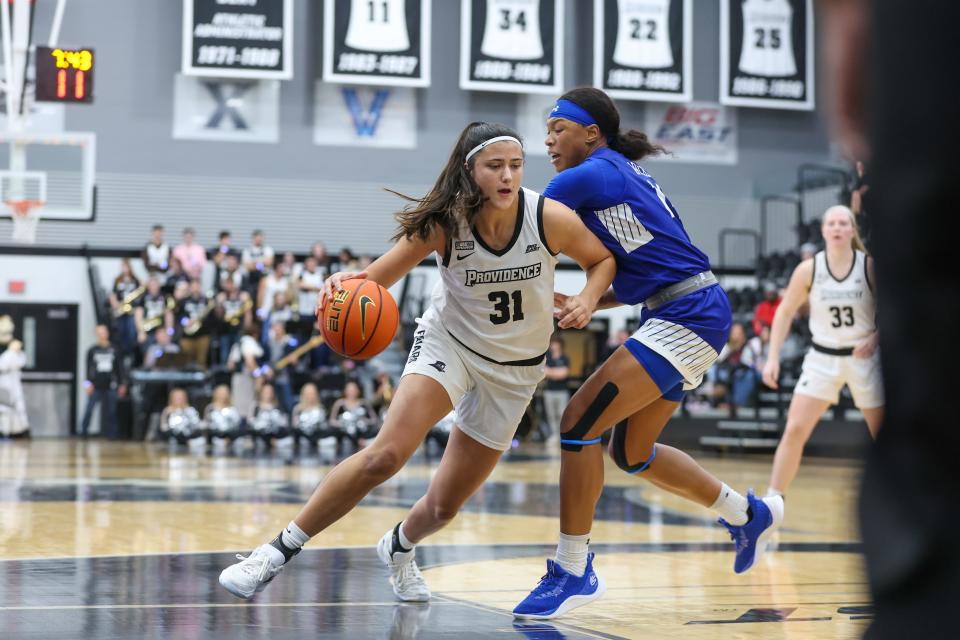Providence's Olivia Olsen drives on a Hampton defender in the season opener. The Providence women's team is going to the WNIT Tournament.