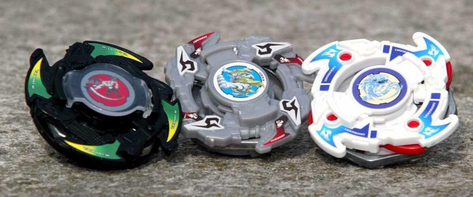 Three Beyblades sitting on the ground