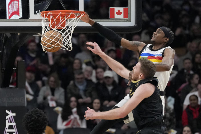 Minnesota Timberwolves forward Jaden McDaniels (3) dunks over Toronto Raptors center Jakob Poeltl (19) during the first half of an NBA basketball game, in Toronto, Saturday, March 18, 2023. (Frank Gunn/The Canadian Press via AP)