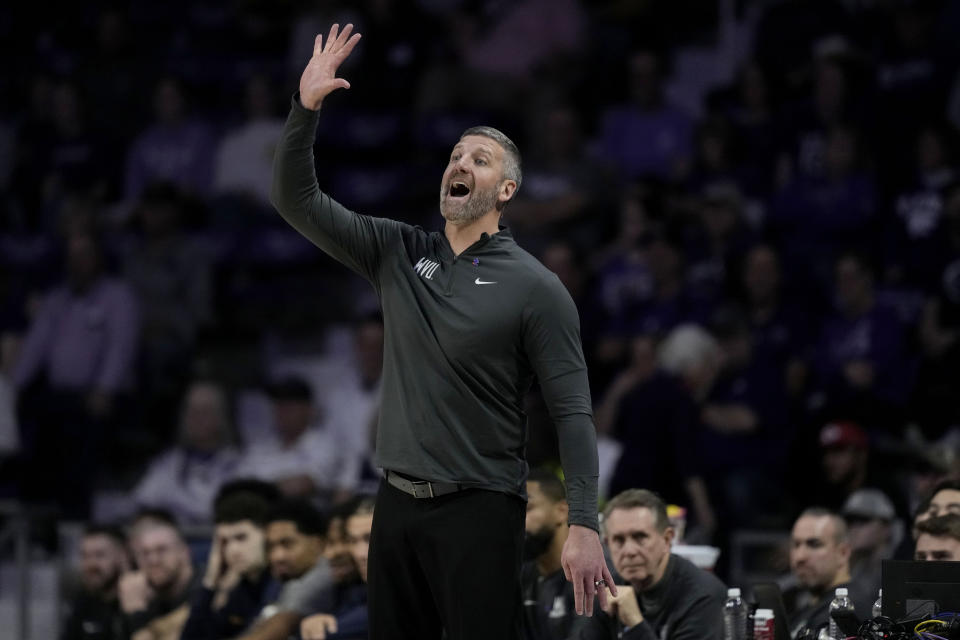 West Virginia interim head coach Josh Eilert motions to his players during the first half of an NCAA college basketball game against Kansas State Monday, Feb. 26, 2024, in Manhattan, Kan. (AP Photo/Charlie Riedel)