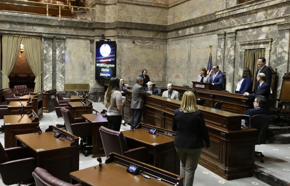Washington Lt. Gov.-elect Cyrus Habib, standing at right the dais, talks with staff members in the Senate chamber, Thursday, Jan. 5, 2017, during a practice session to test technical equipment in Olympia, Wash. Habib, who will preside over the Senate, will be Washington's first blind lieutenant governor, and the Senate has undergone a makeover that incorporates Braille into that chamber's floor sessions that will allow Habib to know by the touch of his finger which lawmaker is seeking to be recognized to speak. Habib is replacing Lt. Gov. Brad Owen, who is retiring. (AP Photo/Ted S. Warren)