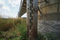 A water gauge plunges in the sand of the Po riverbed under Ponte della Becca (Becca Bridge), in Linarolo, near Pavia, Italy, Saturday, June 25, 2022. The largest Italian river Po is turning into a long stretch of sand due to the lack of rain, leaving the Lomellina rice flats without the water necessary to flood the paddies. (AP Photo/Luca Bruno)