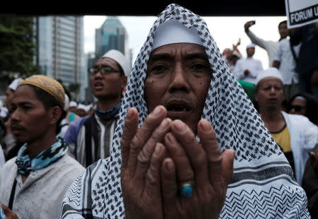 Members of the Islamic Defenders Front (FPI) pray during a protest in front of the Indonesian police headquarters in Jakarta, Indonesia, January 23, 2017. REUTERS/Beawiharta