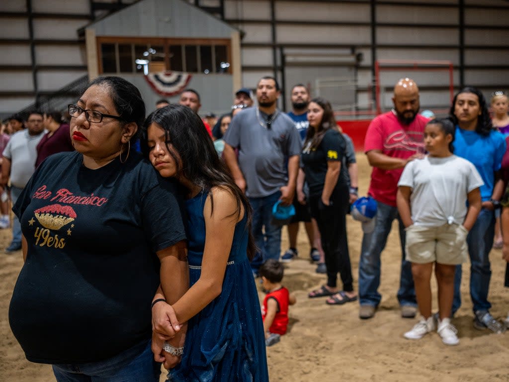 Families stand together at a vigil for the 21 people killed at Rob Elementary School on 25 May in Uvalde (Getty)