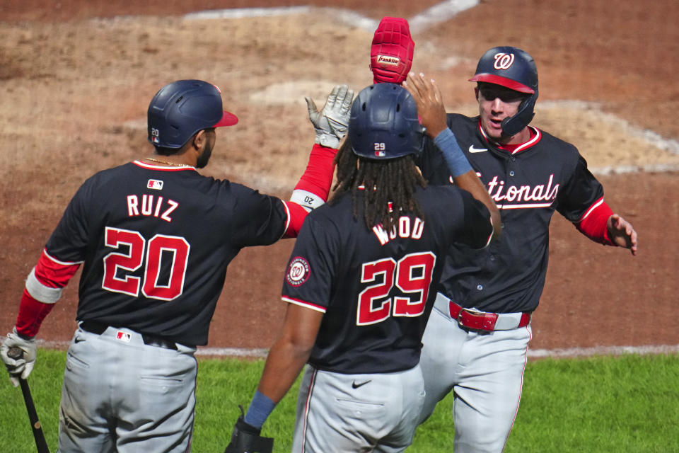 Washington Nationals' Jacob Young, right, celebrates with James Wood (29) and Keibert Ruiz (20) after scoring the second of two runs on a double by Ildemaro Vargas off Pittsburgh Pirates relief pitcher Aroldis Chapman during the ninth inning of the second baseball game of a doubleheader in Pittsburgh, Saturday, Sept. 7, 2024. (AP Photo/Gene J. Puskar)