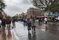 Visitors walk up and down Main Street in Disneyland, enjoying the last few hours until the park closes in Anaheim, Calif., Friday, March 13, 2020. Disneyland is closing its doors for the rest of the month, shuttering one of California's best-known attractions as the state hurries to stop the spread of the coronavirus. (AP Photo/Amy Taxin)