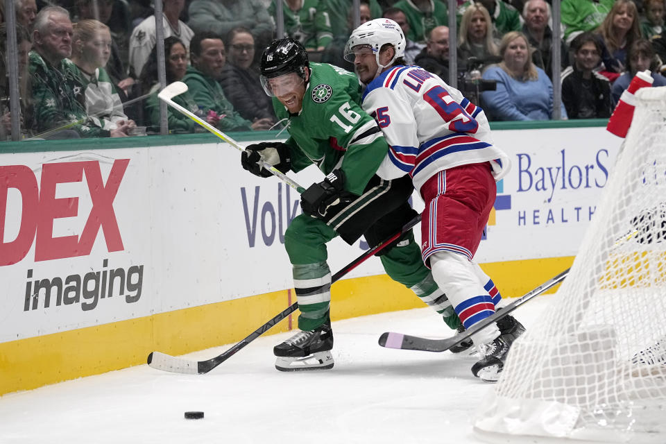 Dallas Stars center Joe Pavelski (16) attempts to reach the puck as New York Rangers defenseman Ryan Lindgren (55) defends in the first period of an NHL hockey game in Dallas, Monday, Nov. 20, 2023. (AP Photo/Tony Gutierrez)