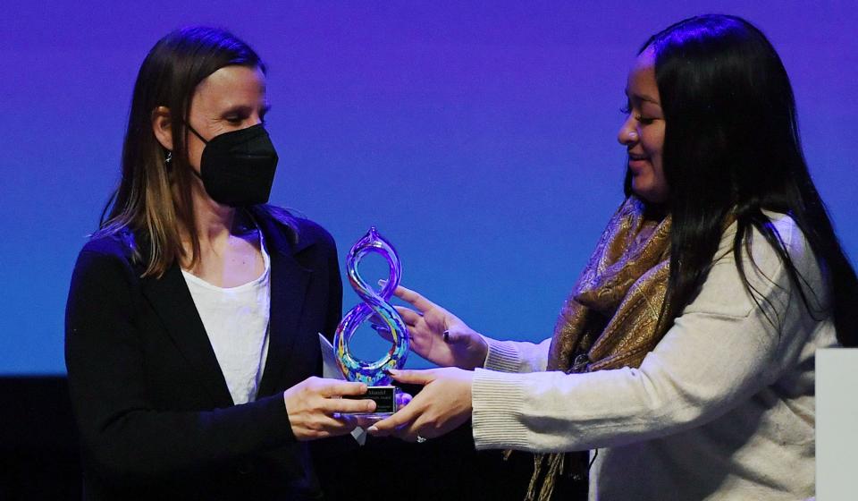 Anneke Mundel of the United Way receives the Ames Humanitarian Award from Jahmai Fisher, the chair of Ames Human Relations Commission, during the Martin Luther King Jr. Day event hosted by the city of Ames at the Ames City Auditorium on Monday, Jan. 17, 2022, in Ames, Iowa.