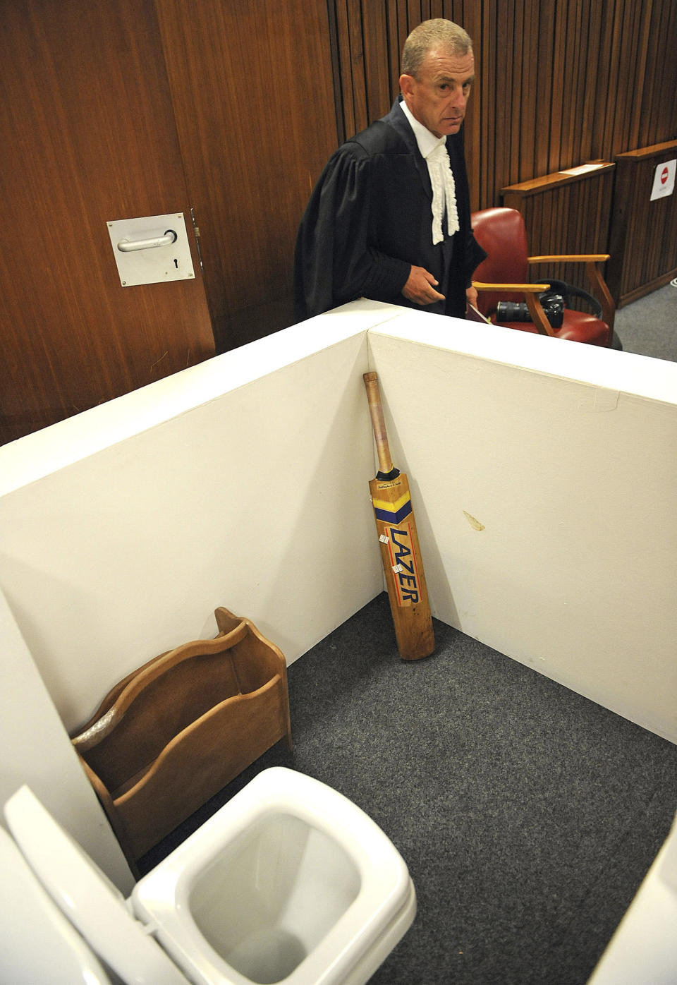 FILE — State prosecutor Gerrie Nel, alongside a reconstruction of a toilet cubicle, in court Monday, April 14, 2014, through which Oscar Pistorius shot and killed his girlfriend, Reeva Steenkamp on St. Valentine's day in 2013. Pistorius shot Steenkamp more than a decade ago in a killing that jolted the world and shattered the image of a sports superstar. (AP Photo/Antoine de Ras, Pool, File)