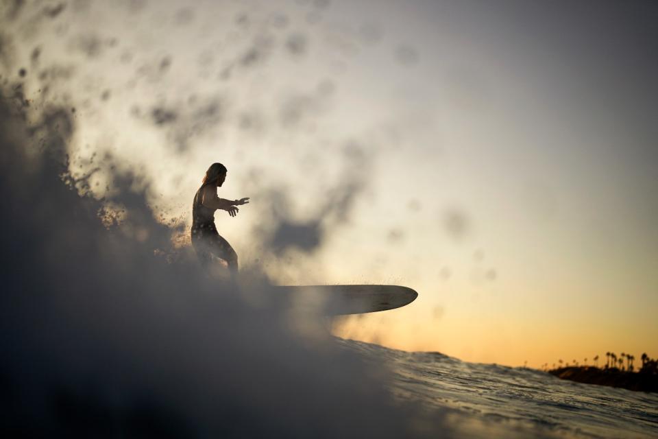 今年海水溫度也創新高，圖為加州1名女子13日衝浪。美聯社