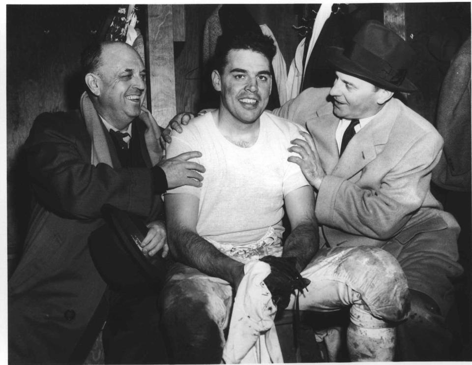 Browns quarterback Otto Graham (center) celebrates with his father (left) and head coach Paul Brown in the dressing room in Cleveland after the Browns routed the Detroit Lions 56-10 in the NFL title game, Dec. 27, 1954.
