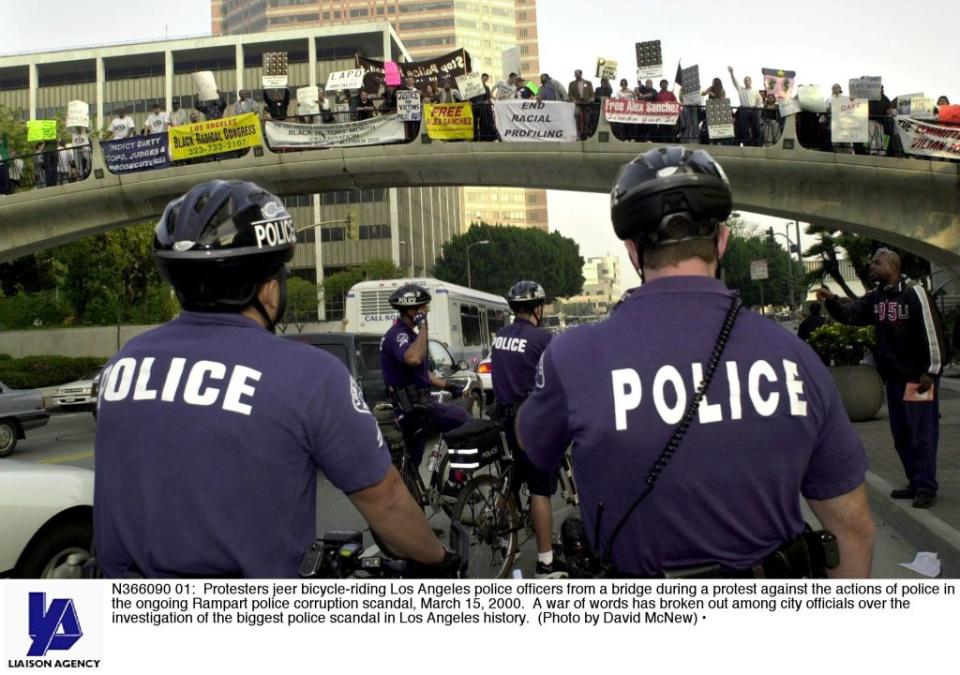 N366090 01: Protesters jeer bicycle-riding Los Angeles police officers from a bridge during a protest against the actions of police in the ongoing Rampart police corruption scandal, March 15, 2000. A war of words has broken out among city officials over the investigation of the biggest police scandal in Los Angeles history. (Photo by David McNew)