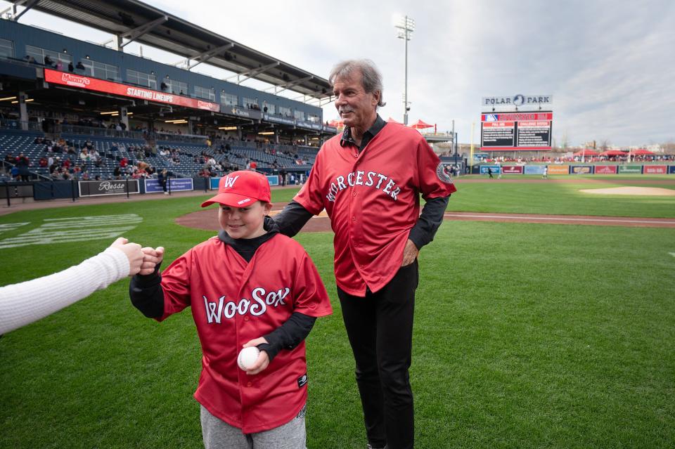 Graham Phillips, a member of the Jimmy Fund, walks off the field after tossing the first pitch with Red Sox great Dennis Eckersley.
