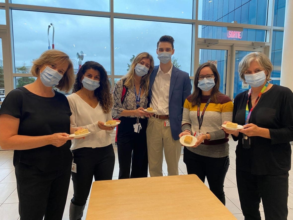 From left to right, Julie Woodfine, Christiane Azzi, Megan Kouri, Brandon Hall, Maryse Fournier and Dr. Marie-Josée Brouillette hold bannock on a plate. The MUHC is offering bannock as a new menu item for First Nations and Inuit patients after a Cree man explained he couldn't eat food that reminded him of his time in residential school. (Submitted by MUHC)  ( - image credit)