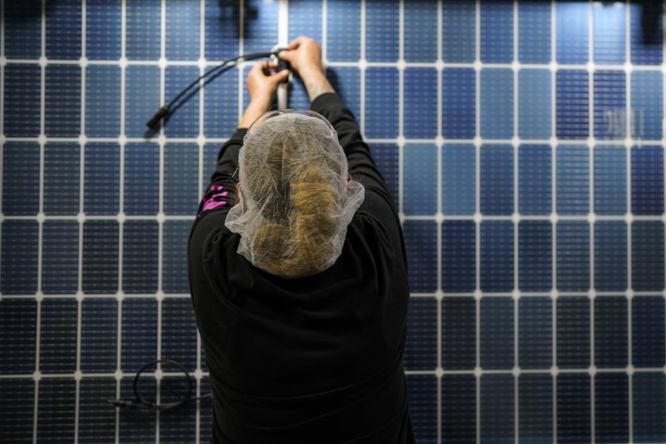 An employee works on a solar panel inside the Hanwha Qcells Solar plant, Monday, Oct. 16, 2023, in Dalton, Ga. The Korean company is opening what it says is the first solar panel factory to begin production in the U.S. since the passage of President Joe Biden’s signature climate legislation. (AP Photo/Mike Stewart)