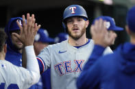 Texas Rangers' Jonah Heim is greeted in the dugout after scoring during the fifth inning of a baseball game against the Detroit Tigers, Monday, April 15, 2024, in Detroit. (AP Photo/Carlos Osorio)