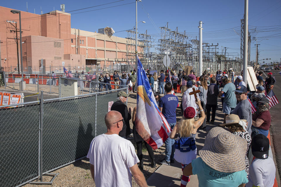 FILE - Republican supporters stand outside the Maricopa County Recorder's Office to protest what they allege is an unfair election in Phoenix, on Saturday, Nov. 12, 2022. Democratic Sen. Mark Kelly urged Arizonans to let go of "conspiracies of the past," calling for unity a day after he won re-election to a crucial Senate seat. Officials in Arizona's most populous county have become adept at batting down slanted or false claims about how they ran the midterm election and are counting ballots. (AP Photo/Alberto Mariani, File)