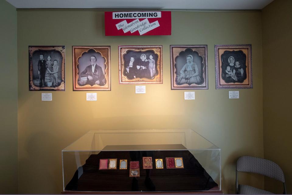 A display of original faint daguerreotypes by Glenalvin Goodridge are displayed in the case below and enhanced and reproduced on the wall above.