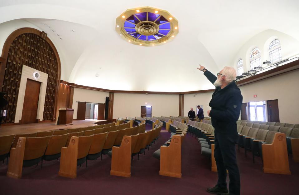 Tony Troppe points out the ocular window in the sanctuary of the former Temple Israel which is now the Highland Square Universal Gathering Place, HUG art center, on Thursday.