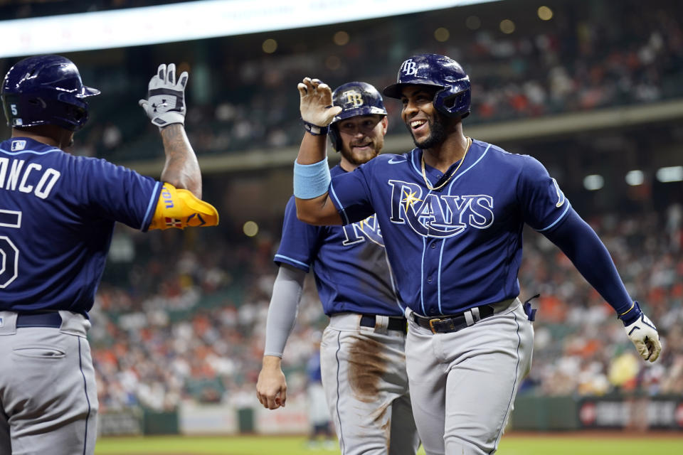 Tampa Bay Rays' Yandy Diaz, right, celebrates with Wander Franco, left, after hitting a two-run home run against the Houston Astros during the first inning of a baseball game Tuesday, Sept. 28, 2021, in Houston. Tampa Bay Rays' Brandon Lowe, rear, scored on Diaz's homer. (AP Photo/David J. Phillip)