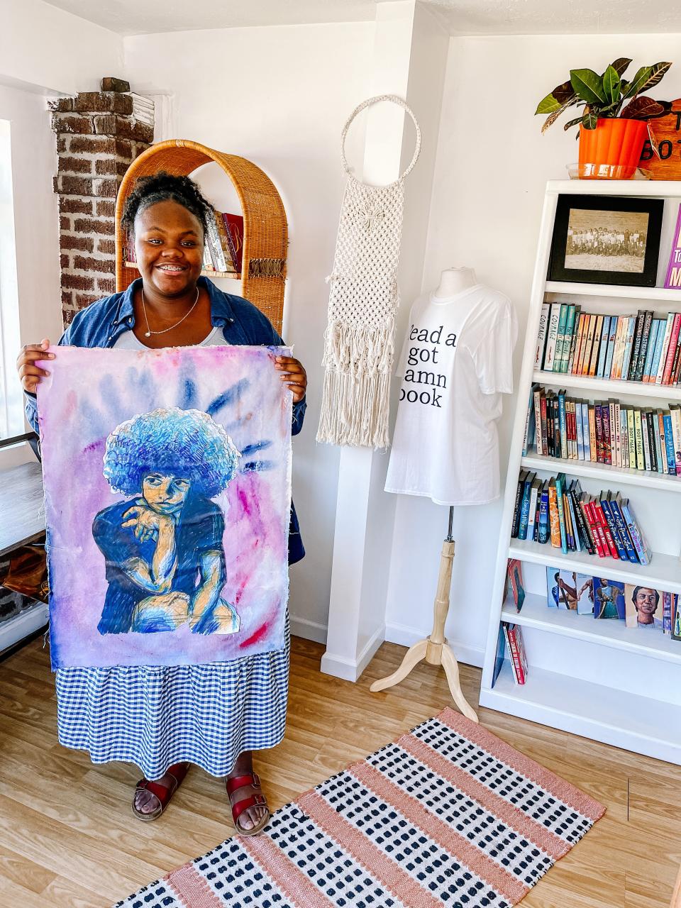 Trinity Anthony with a piece of her art at The Bottom on Aug. 4, 2022, the day before her first solo exhibition opens to the public.