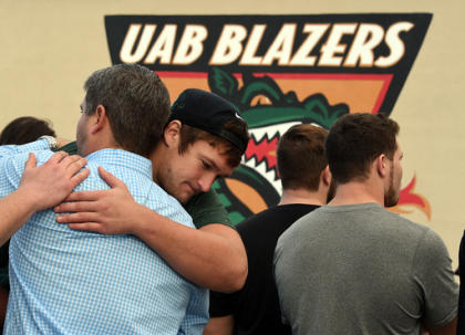 FILE - In this Dec. 2, 2014, file photo, UAB offensive tackle Steve Pickern hugs UAB supporter Justin Craft after UAB President Ray Watts announced the shut down of the UAB football program in Birmingham, Ala. (AP Photo/AL.com, Joe Songer, File)