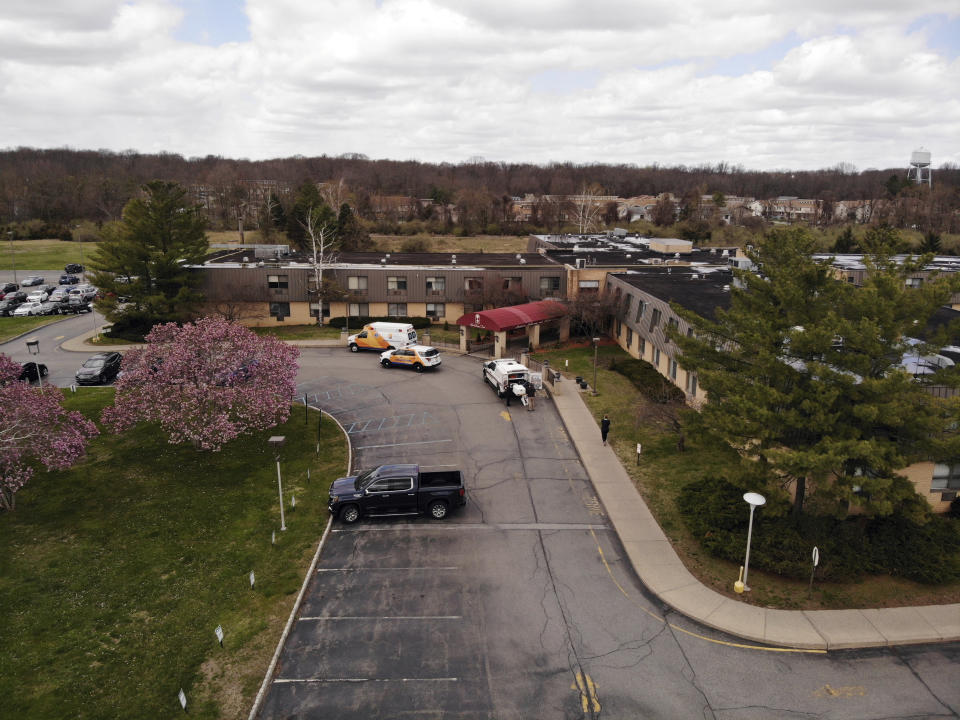 Ambulance crews are parked outside Andover Subacute and Rehabilitation Center in Andover, N.J., on Thursday April 16, 2020. Police responding to an anonymous tip found more than a dozen bodies Sunday and Monday at the nursing home in northwestern New Jersey, according to news reports. (AP Photo/Ted Shaffrey)