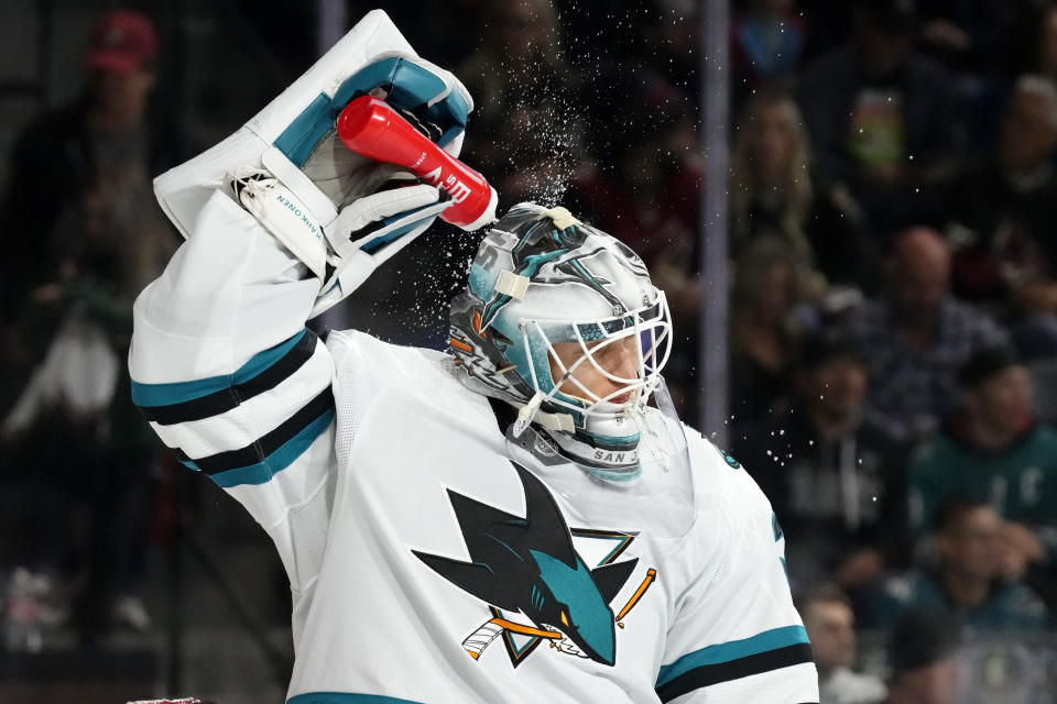 San Jose Sharks goaltender Kaapo Kahkonen splashes water onto his helmet during the first period of the team's NHL hockey game against the Arizona Coyotes on Friday, Dec. 15, 2023, in Tempe, Ariz. (AP Photo/Ross D. Franklin)