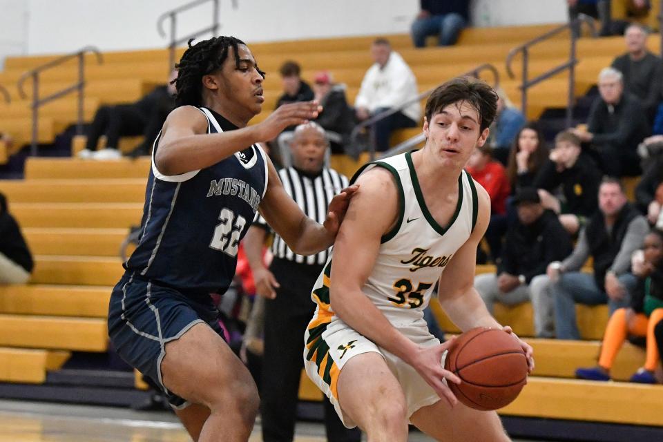 St. Xavier's Will Hanke (35) attempts to get past Moore’s Jerry Bartlett during the first half. Hanke scored a game-high 24 points in the Tigers' victory Monday night in the first round of the LIT.