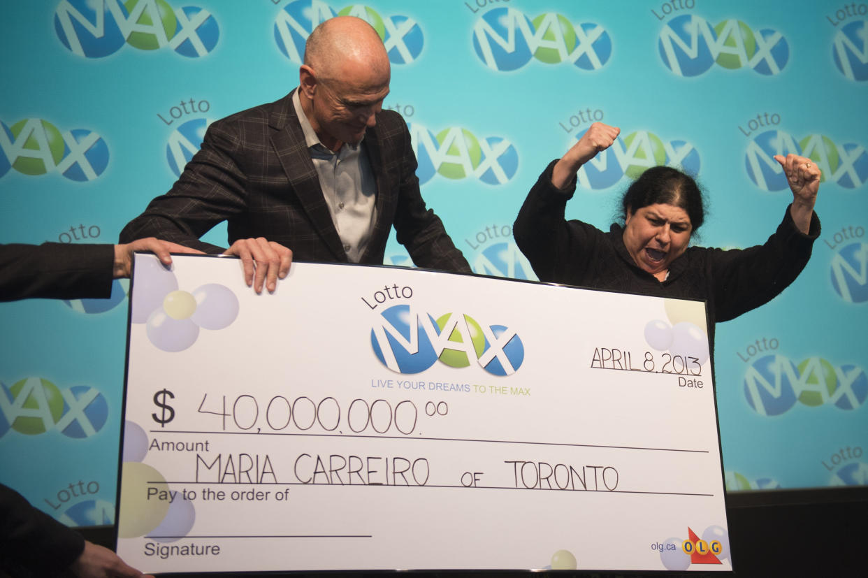 TORONTO, ON - APRIL 8: Senior VP Lottery Ken McKenzie presents Maria Carreiro with the $40 million cheque. Maria Carreiro won the $40 million LOTTO MAX jackpot on the Friday April 5 draw. She says that after thirty ears of marriage she is finally going on her dream Hawaiian honeymoon. Carlos Osorio/Toronto Star via Getty Images)