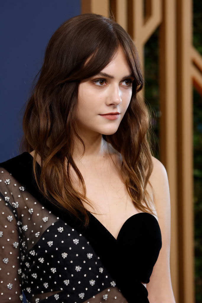 up close, the sparkles on her cover-up look like flowers, and her medium-length hair is wavy